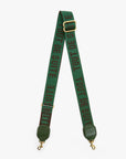 A green woven shoulder strap with gold-tone hardware, featuring the text 'TOUT DE SUITE' printed repeatedly in dark green. The strap is displayed in a V-shape against a light gray background.