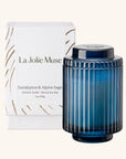 Blue candle with ribbed design and 'La Jolie Muse' packaging on a white background
