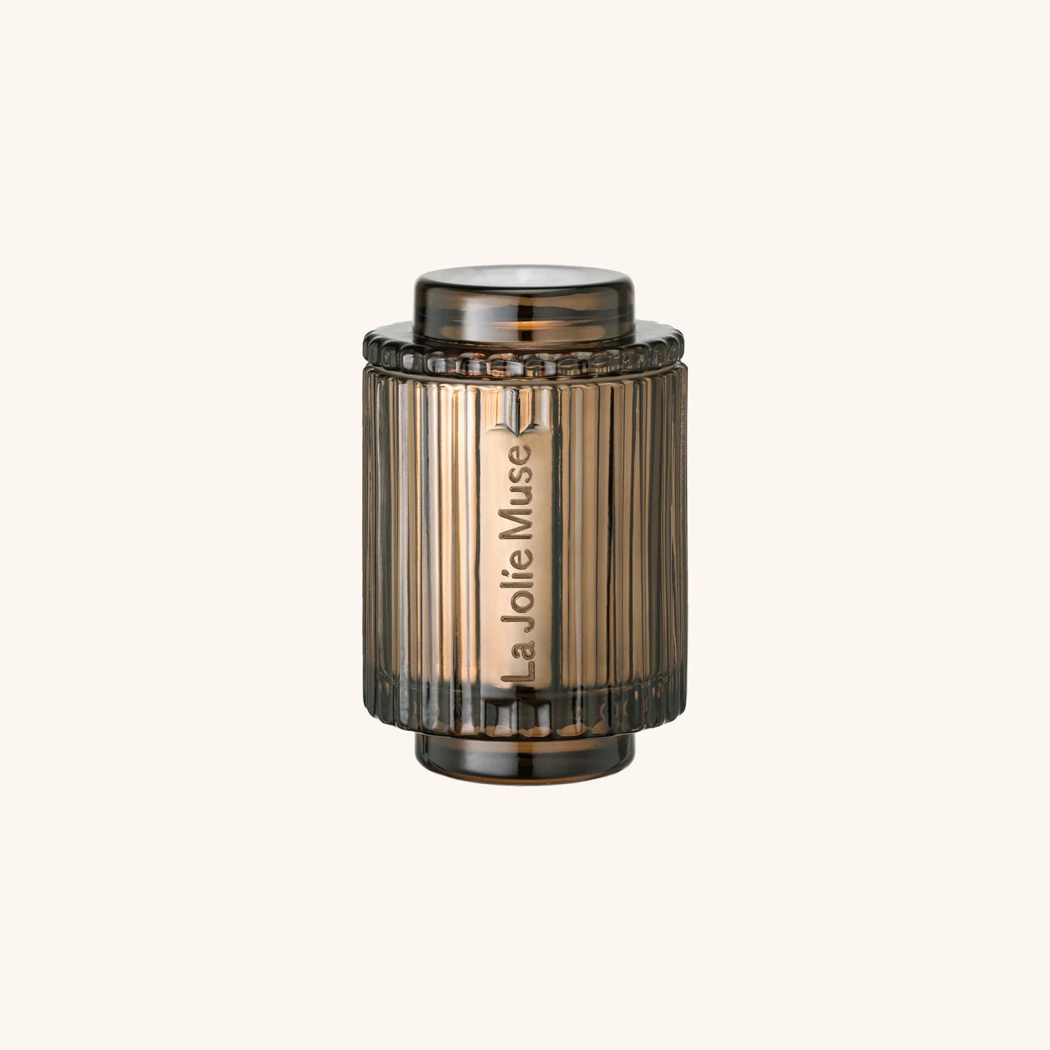 Bronze-colored cylindrical object with 'La Jolie Muse' branding on a white background