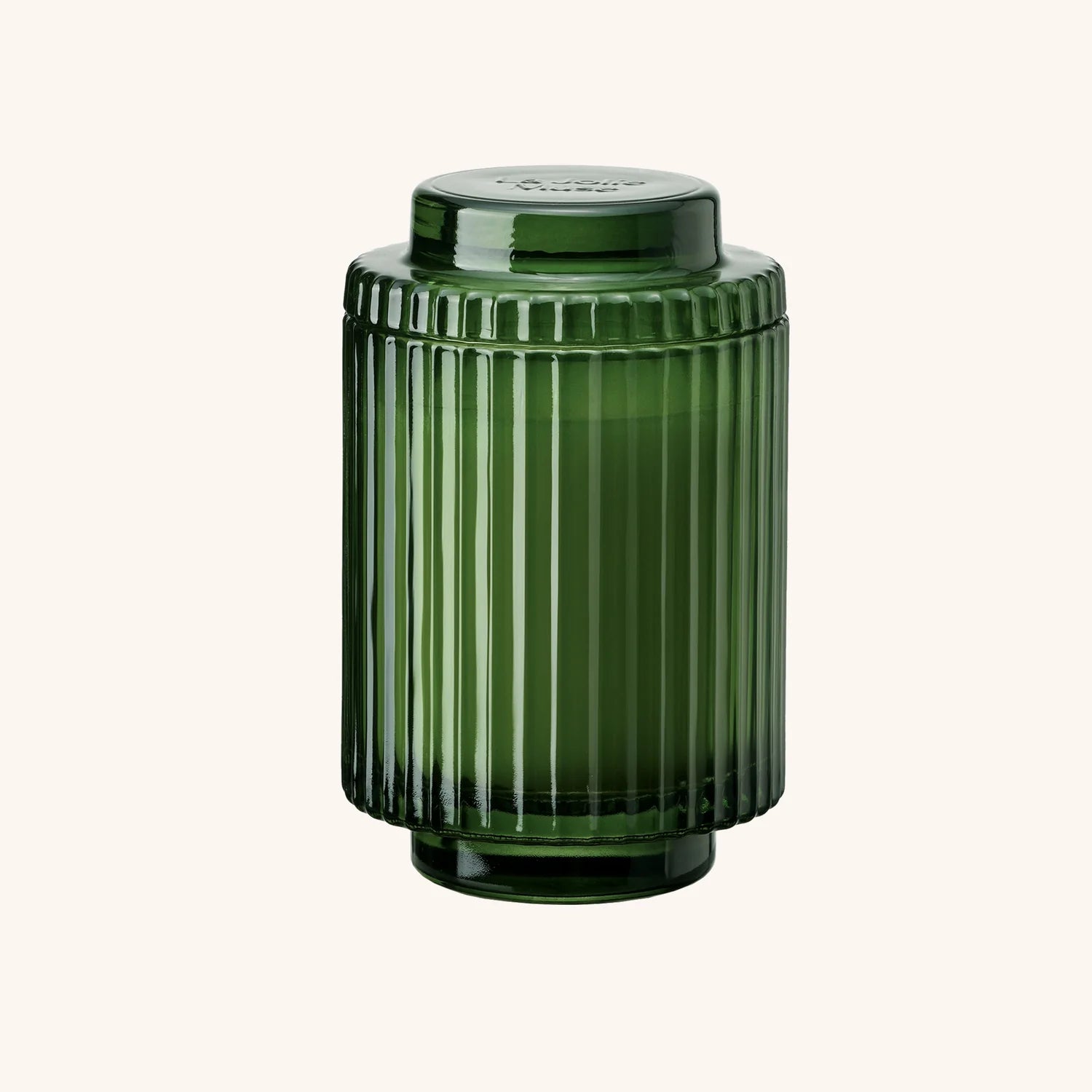 Green ribbed glass jar on a white background