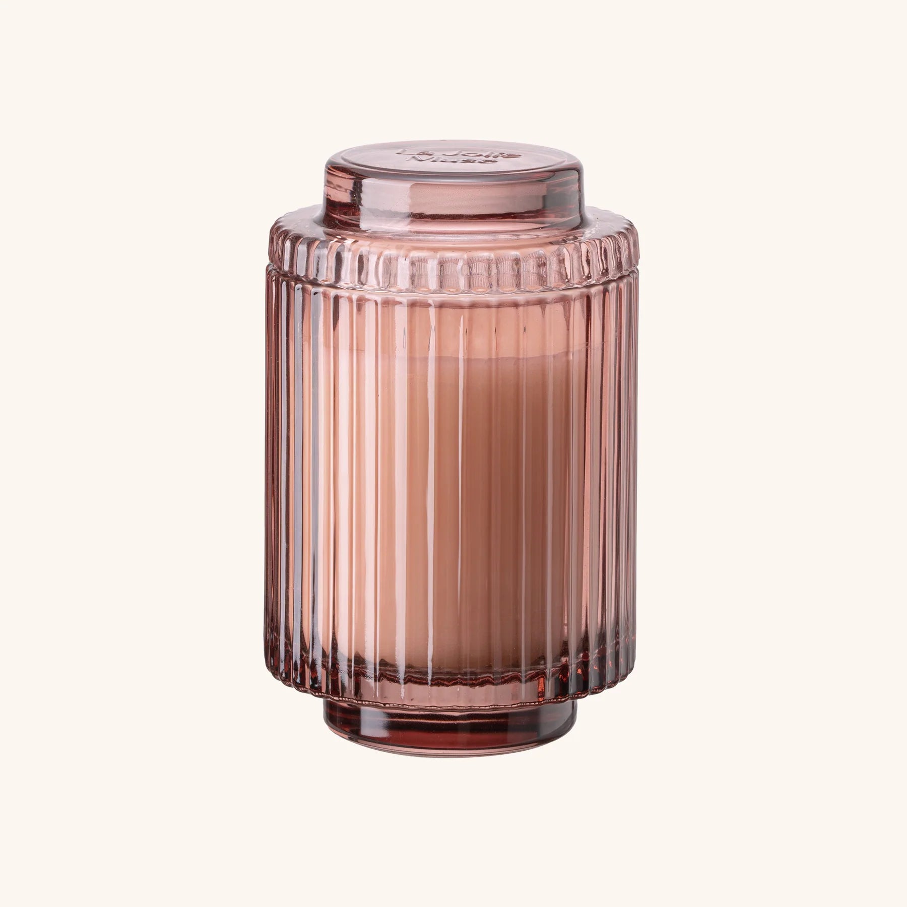 Pink ribbed glass jar on a white background