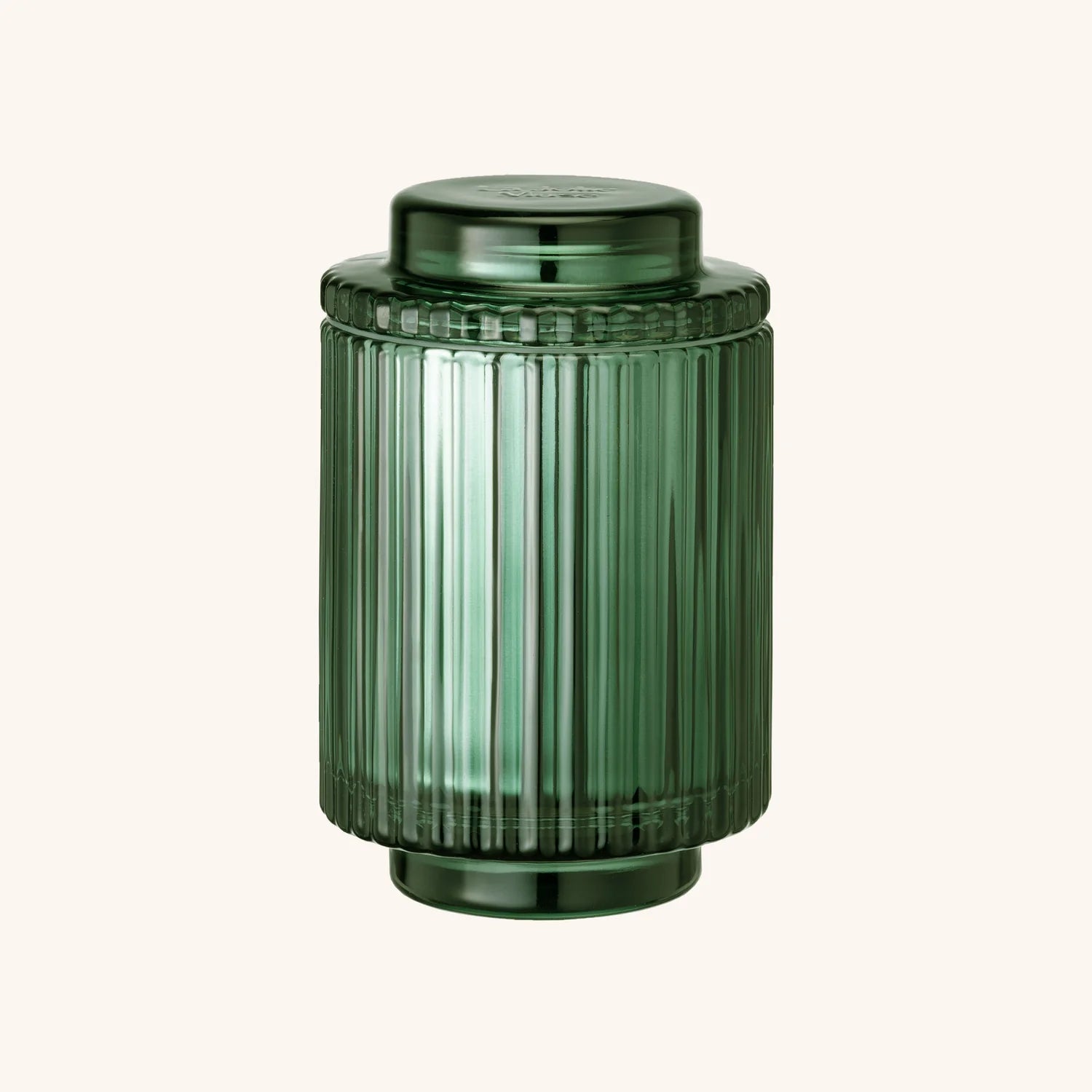 Green ribbed candle jar on a white background