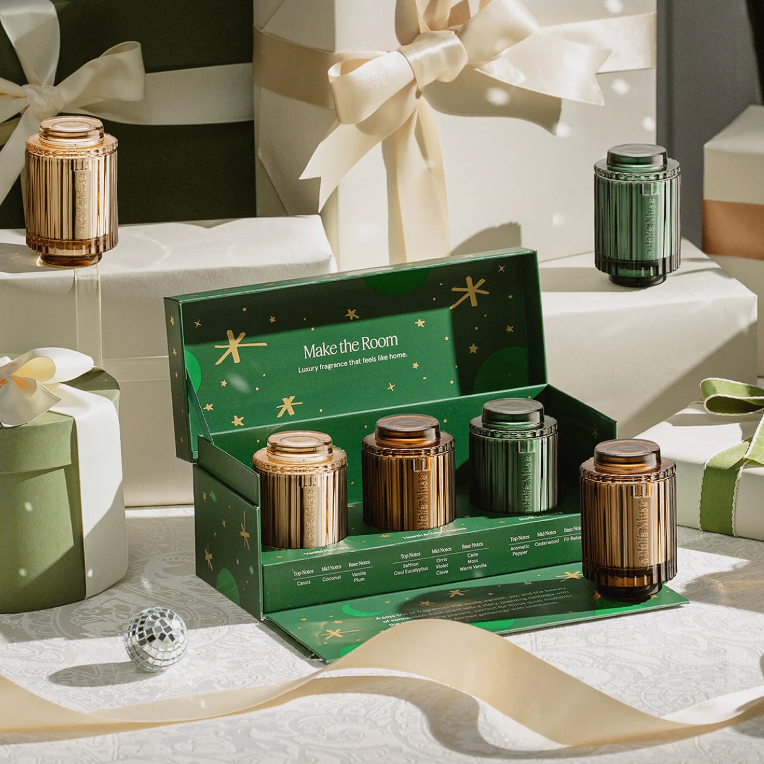 Set of candles in a decorative box with gift boxes and ribbons in the background