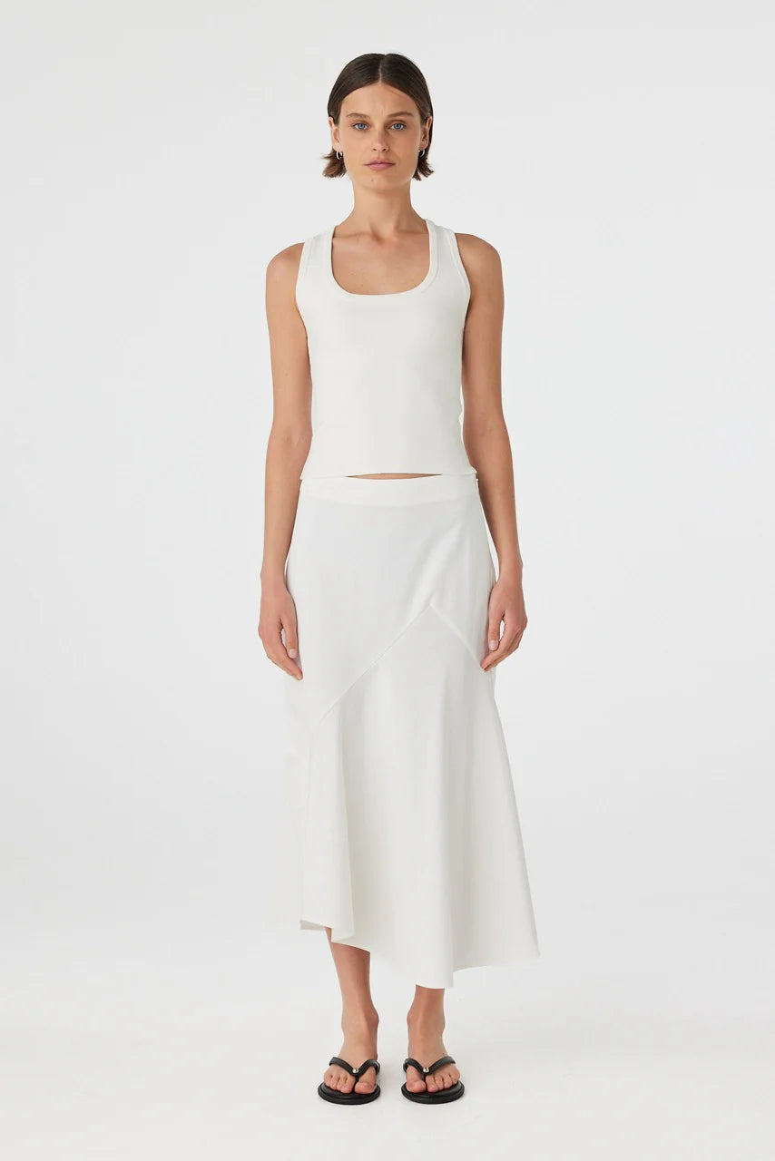Woman wearing a white sleeveless top and skirt on a white background