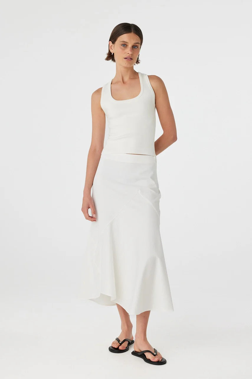 Woman wearing a white sleeveless top and skirt set on a white background