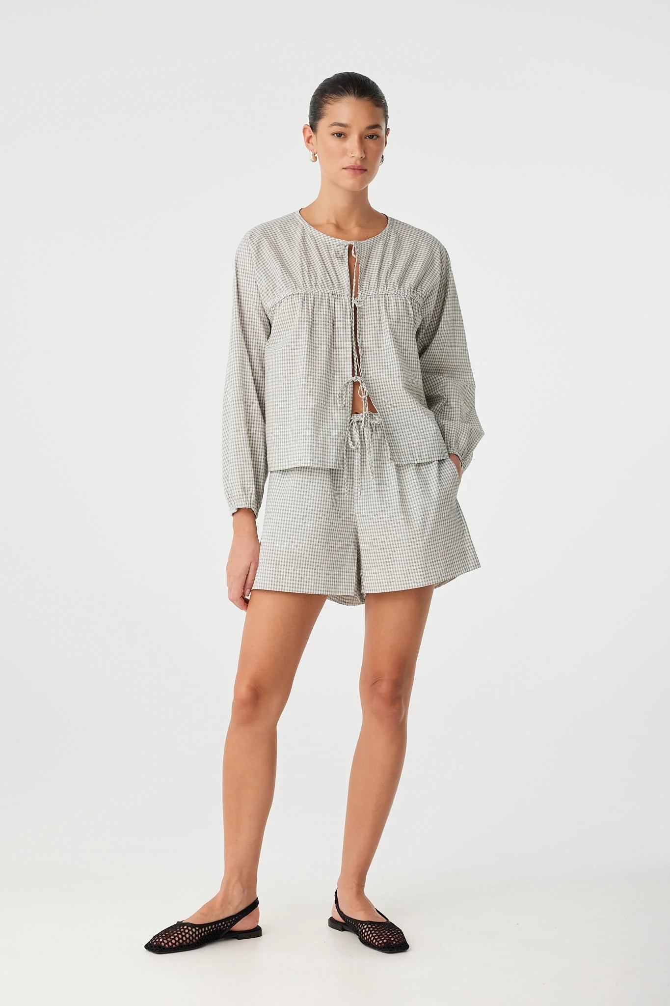 Woman wearing a light gray outfit on a white background
