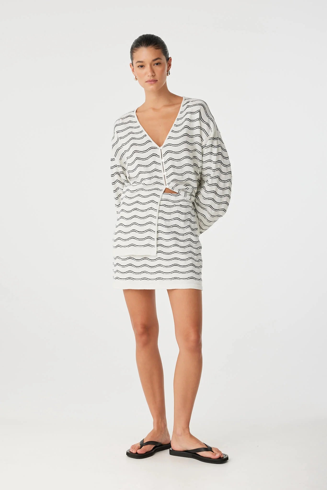 Woman wearing a striped cardigan on a white background