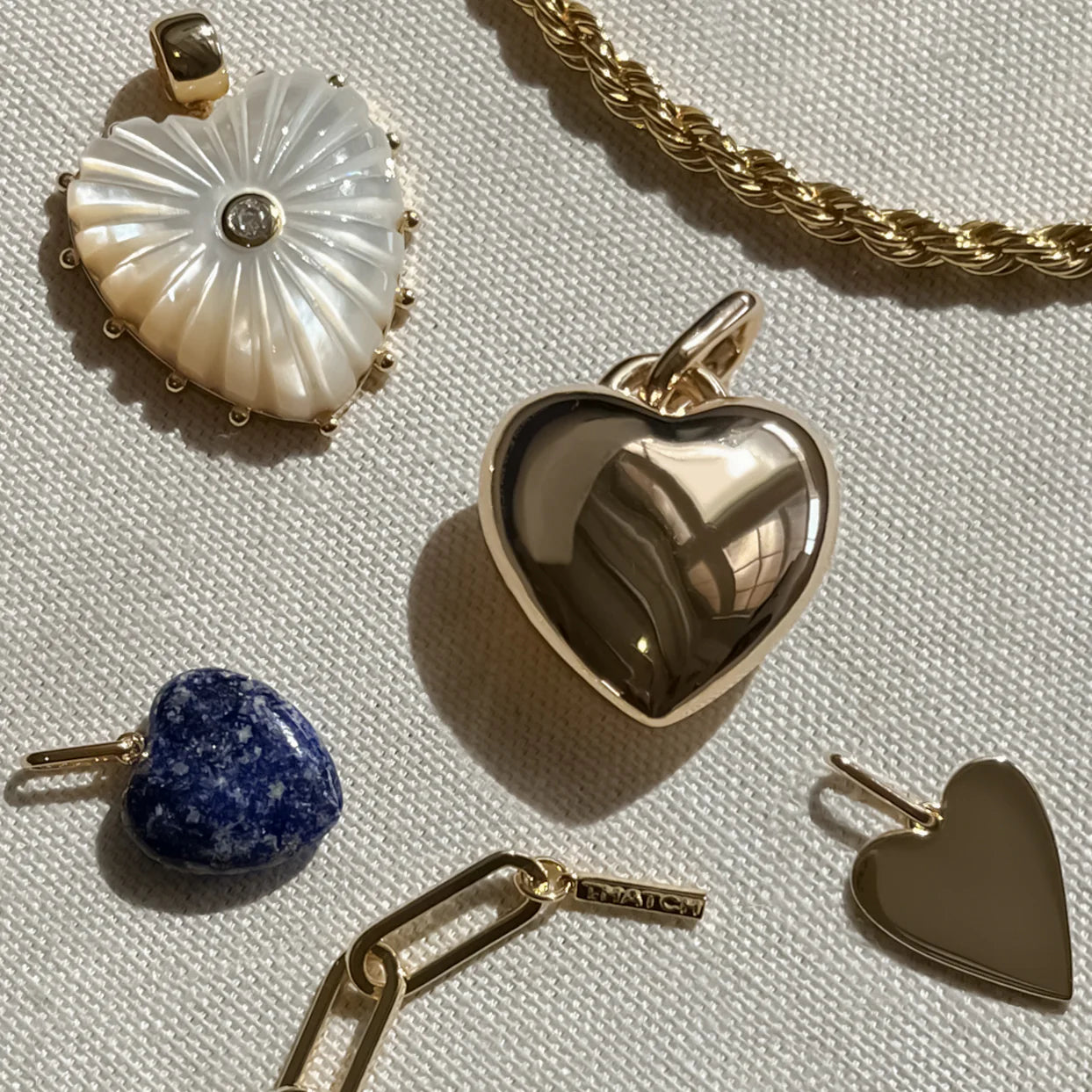 Collection of heart-shaped pendants on a textured surface