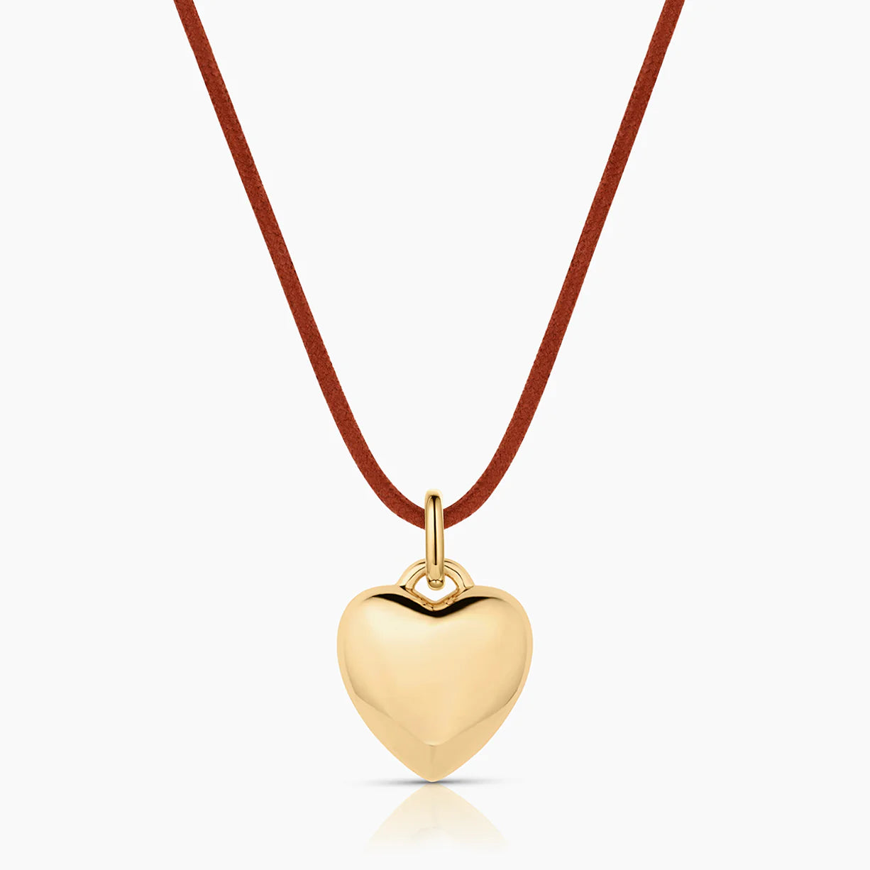 Gold heart-shaped pendant on a red cord against a white background