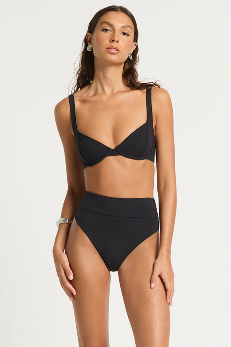 model wearing black bikini with white background