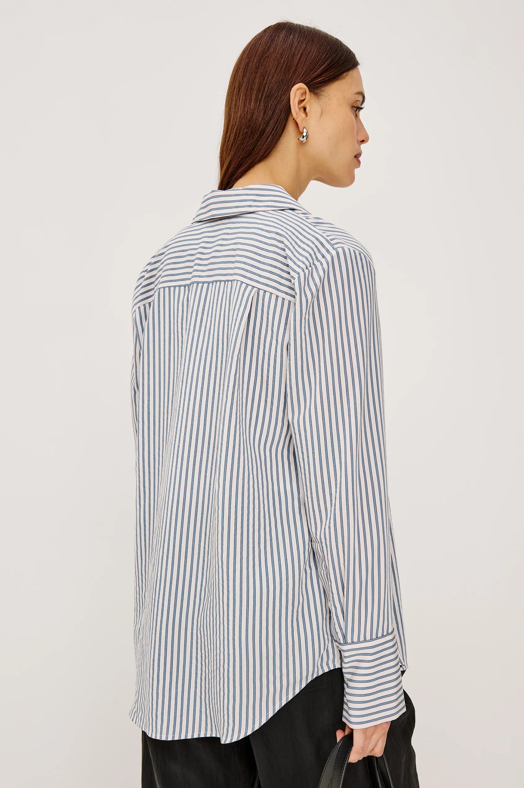 Woman wearing a striped shirt against a plain background