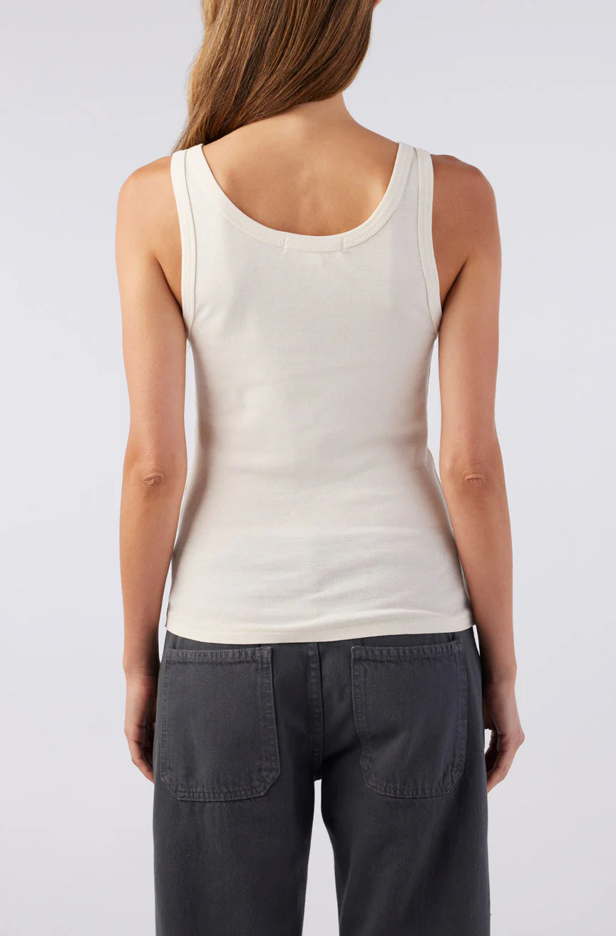 Person wearing a white tank top and dark pants on a plain background