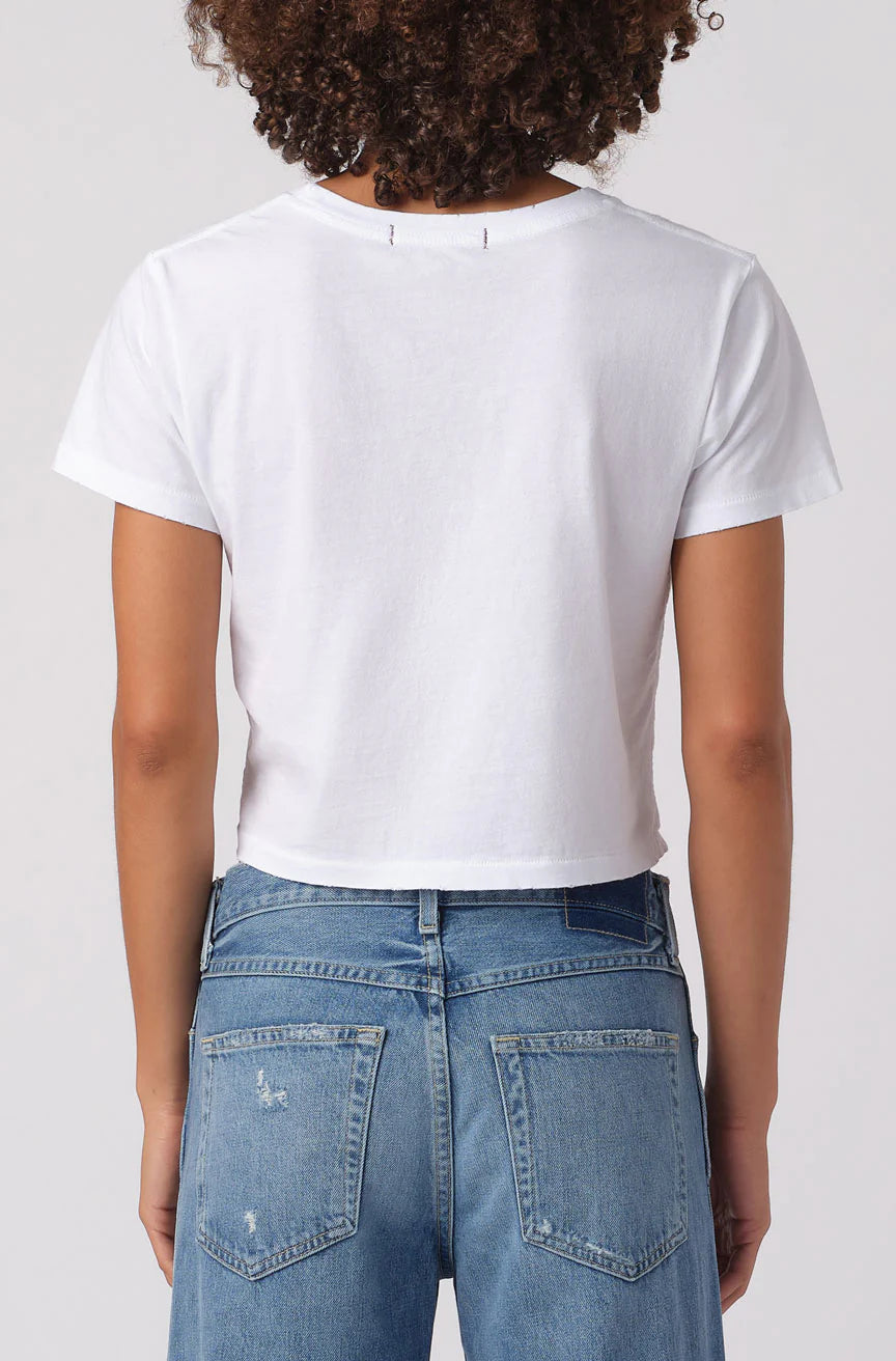 Person wearing a white t-shirt and blue jeans on a plain background