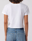 Person wearing a white t-shirt and blue jeans on a plain background