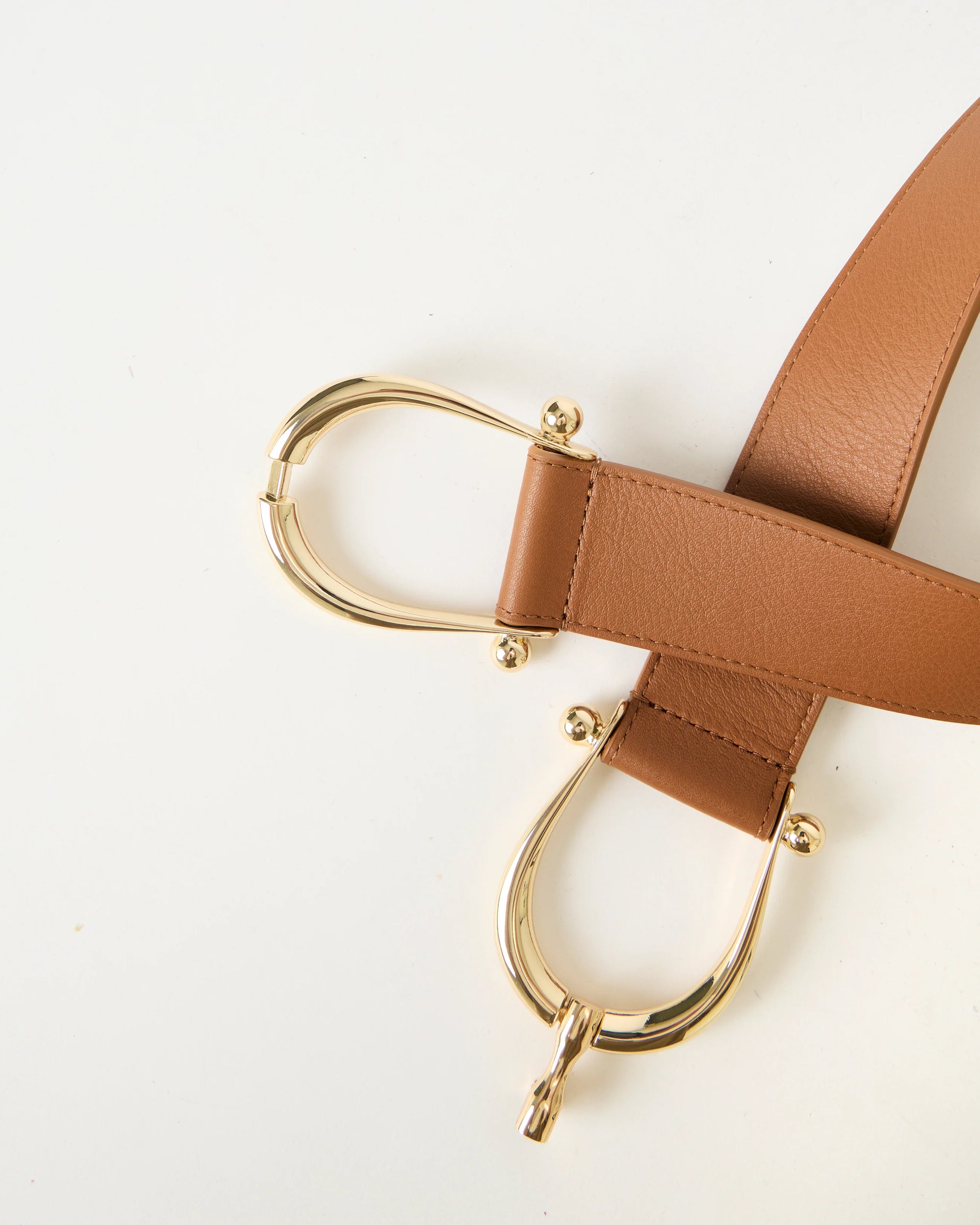 Brown leather belt with gold hardware on a white background