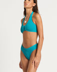 model wearing a blue bikini on white background