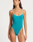 model wearing a blue one piece on white background