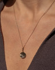 Birth of Venus Charm front view attached to small chain necklace on model