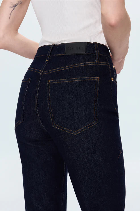 Dark blue jeans worn by a person on a light gray background