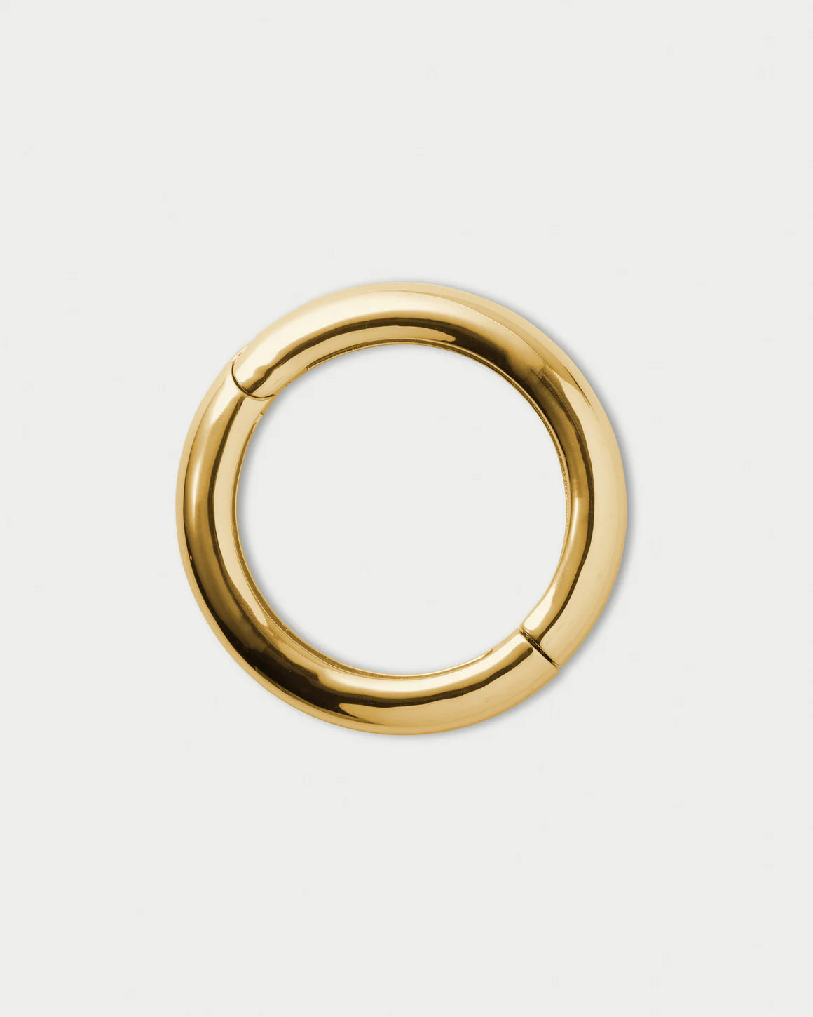Gold circular bangle bracelet on a white background