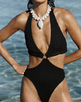 model wearing a black cut out one piece 