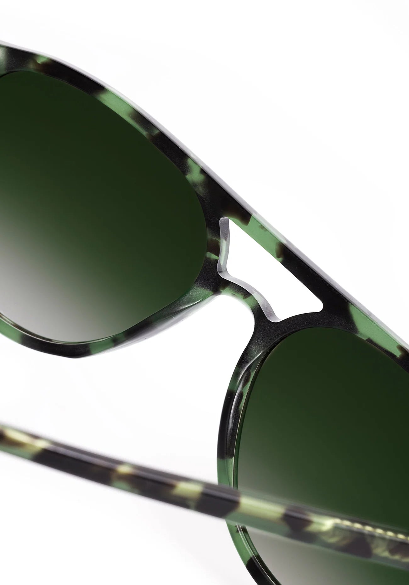 Sunglasses with green lenses and a distinctive frame design on a white background