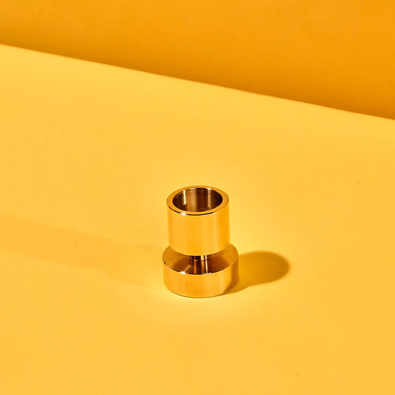 Gold cylindrical object on a yellow background