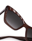 Brown sunglasses with dark lenses on a white background