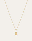 A delicate gold chain necklace with a small lowercase letter 'a' pendant, displayed against a solid off-white background.