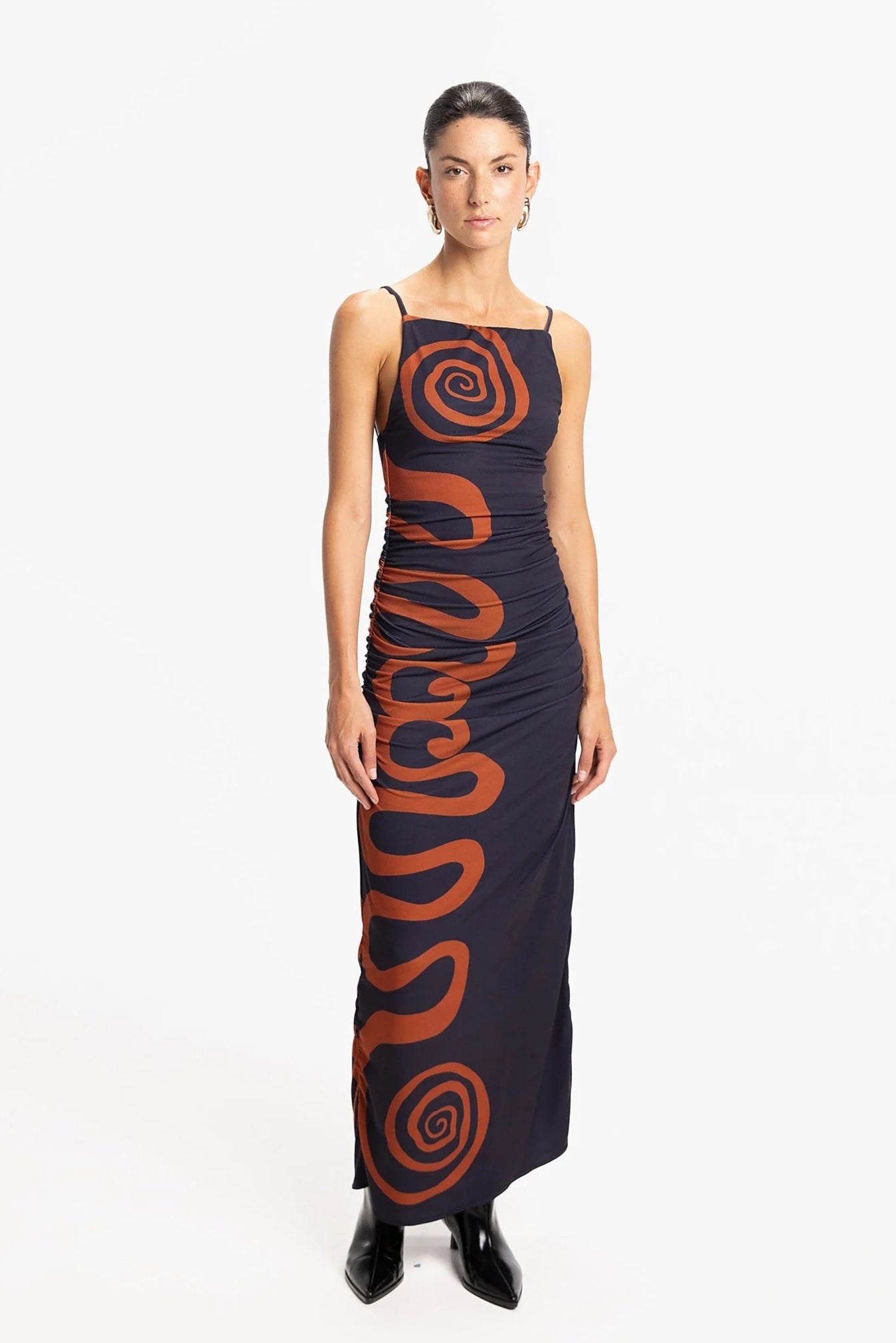Woman wearing a long dress with a spiral pattern on a white background