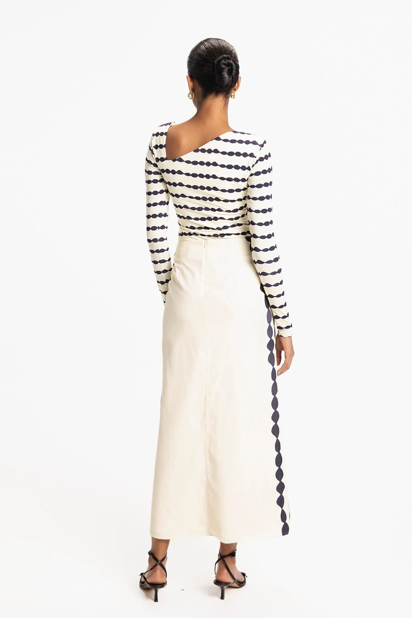 Woman wearing a Navy and white striped dress with a long train on a white background, back view