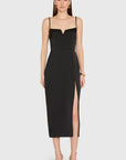 Woman wearing a black dress with a slit on a white background