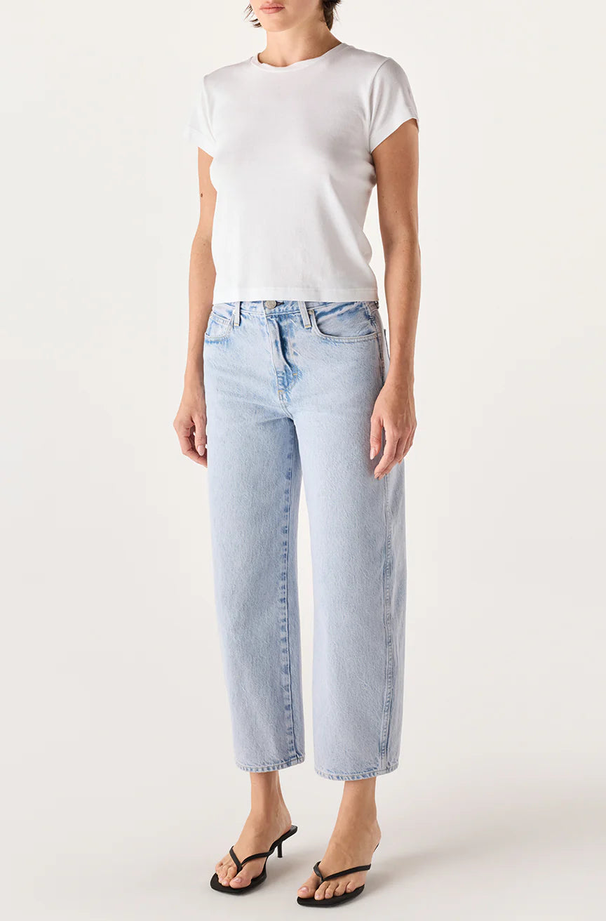Person wearing a white t-shirt and light blue jeans on a plain background