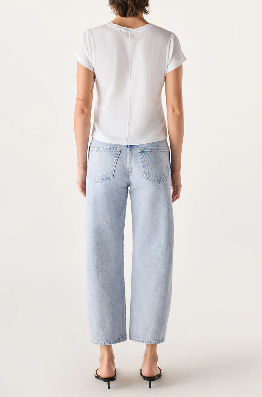 Person wearing a white top and light blue jeans on a white background