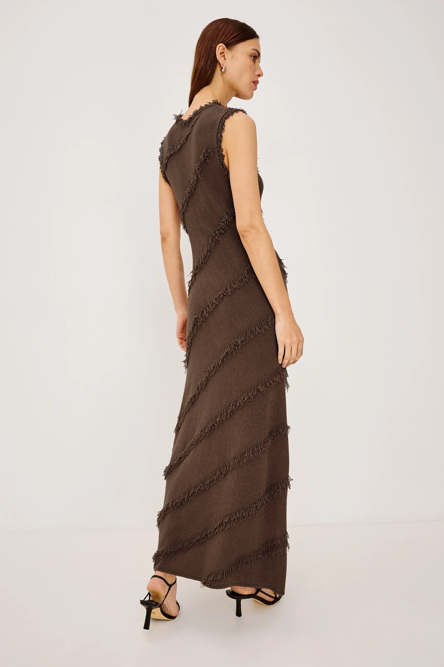 Woman wearing a brown ruffled dress on a white background