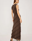 Woman wearing a brown ruffled dress on a white background