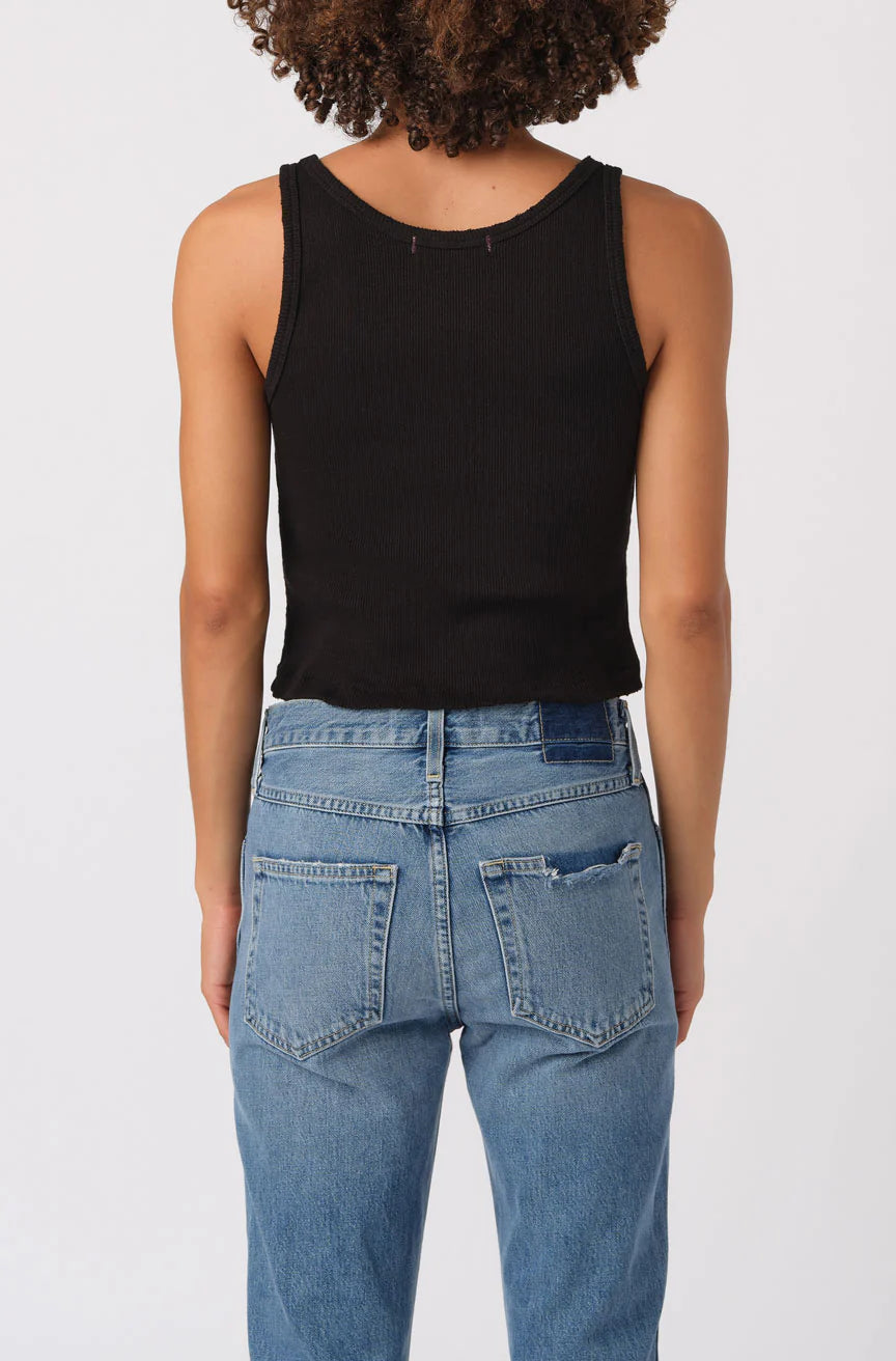 Person wearing a black tank top and blue jeans on a white background