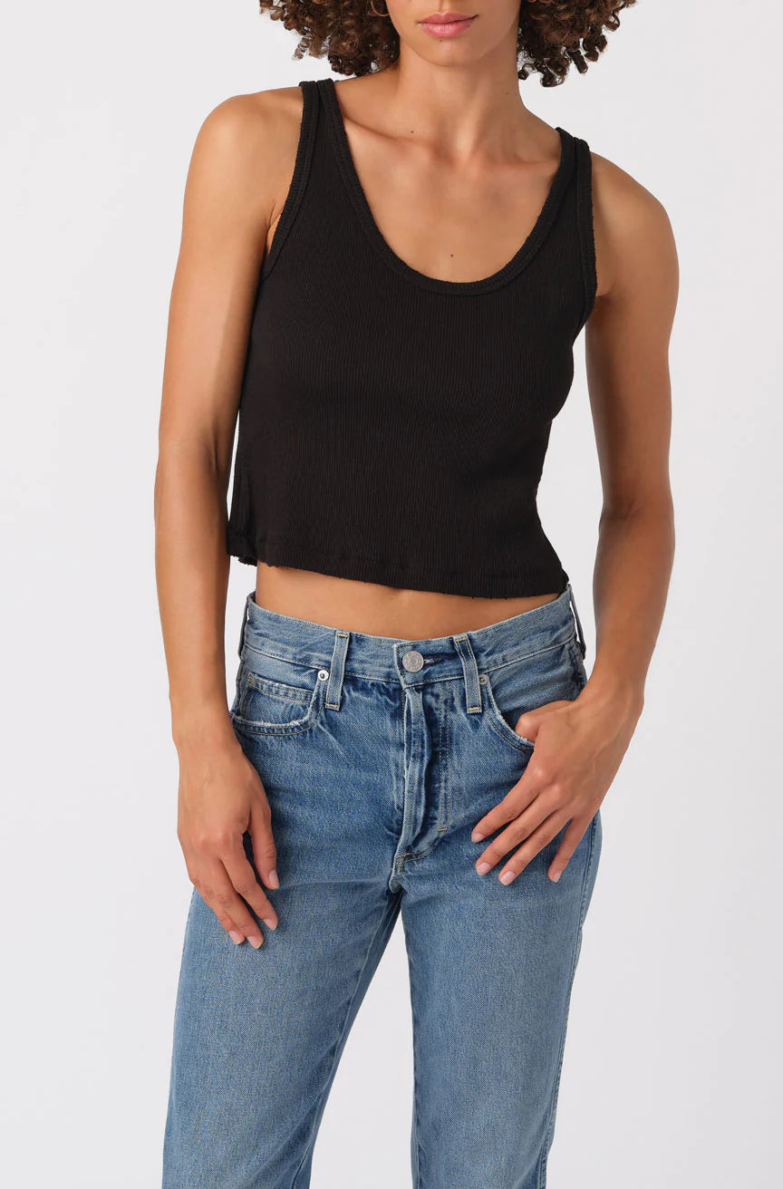 Person wearing a black tank top and blue jeans on a white background
