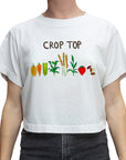 A white short-sleeve crop top t-shirt featuring a colorful graphic of various vegetables and grains with the text 'CROP TOP' printed above them, shown on a model.
