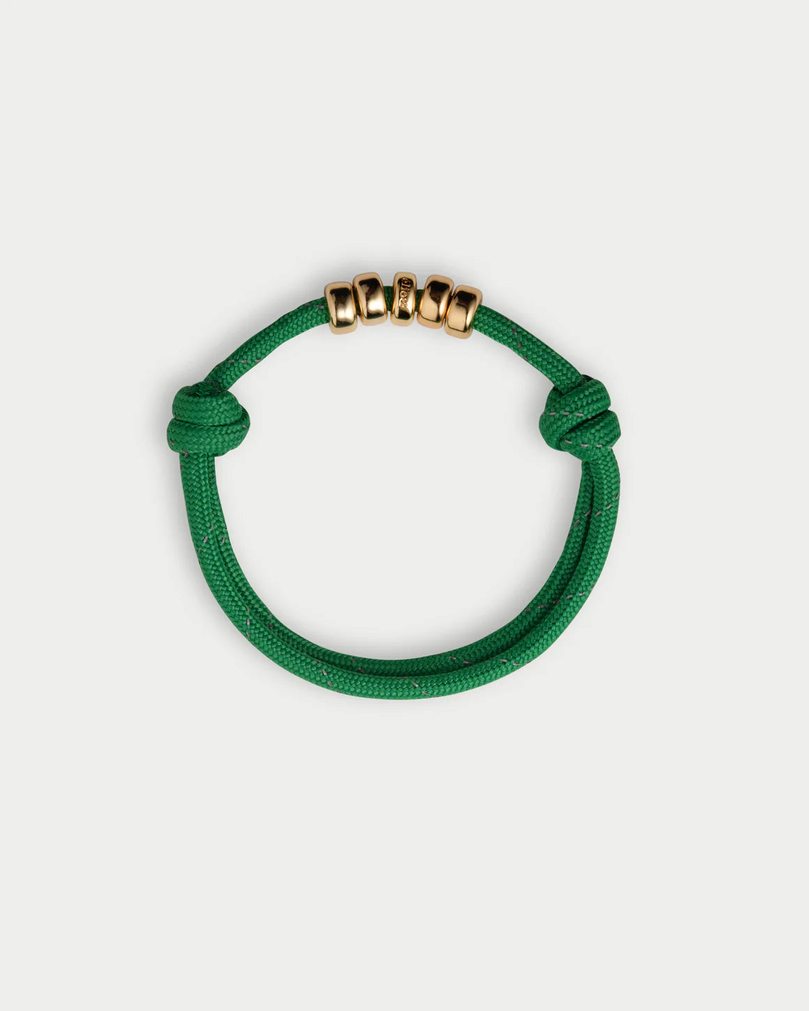 Green bracelet with gold beads on a white background