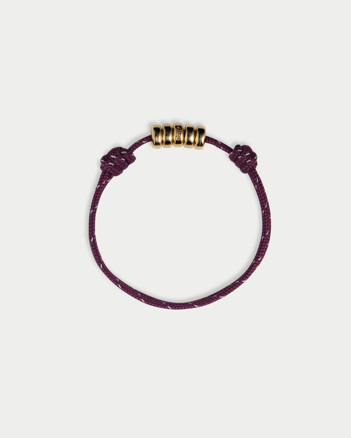 Purple bracelet with gold beads on a white background