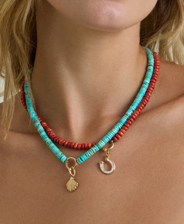 model wearing charm enhancer turquoise gemstone necklace layered with a coral necklace