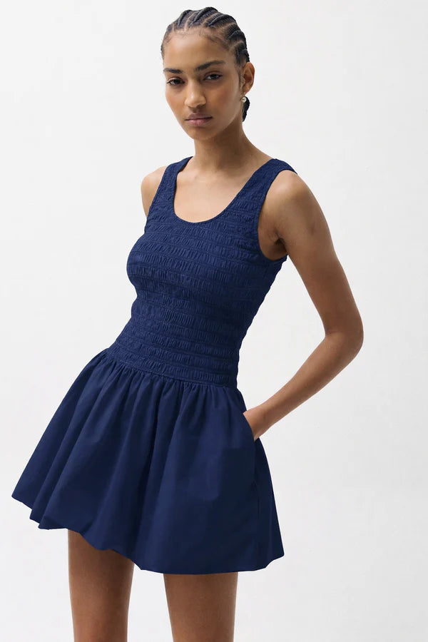 Woman wearing a blue dress against a white background