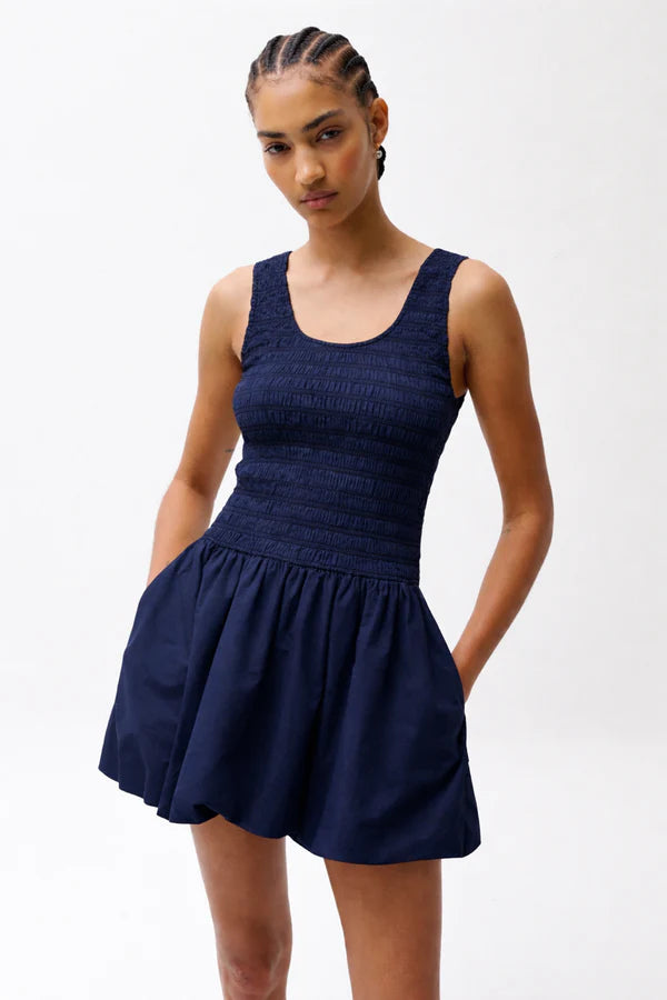 Woman wearing a navy blue dress against a white background