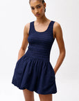 Woman wearing a navy blue dress against a white background