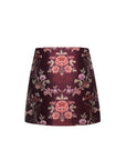 A structured A-line mini skirt in a dark burgundy brocade fabric with a pink and beige floral pattern, shown against a plain white background.