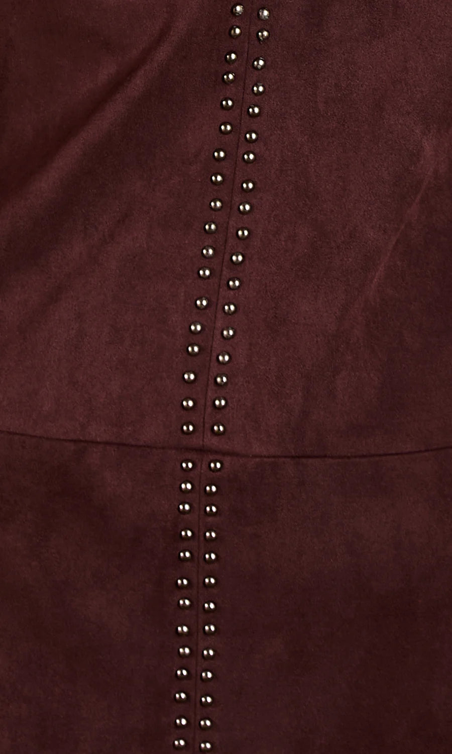 Close-up of a dark burgundy suede or faux-suede material with a vertical row of metallic silver studs down the center.