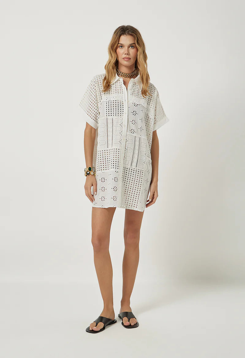 Woman wearing a white lace dress on a plain background