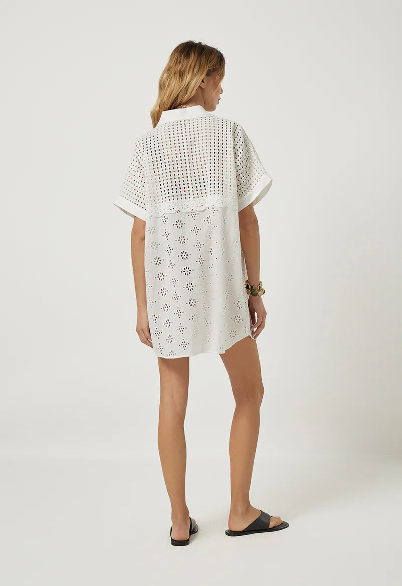 Woman wearing a white lace dress on a plain background