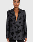 Woman wearing a dark floral blazer on a white background front